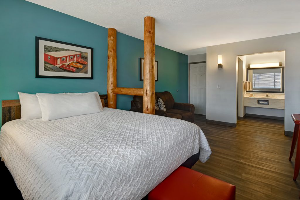 Pioneer Room at Expedition Lodge Moab featuring a Queen-sized bed, cozy living area, minifridge, microwave, and coffee maker—ideal for solo travelers or couples